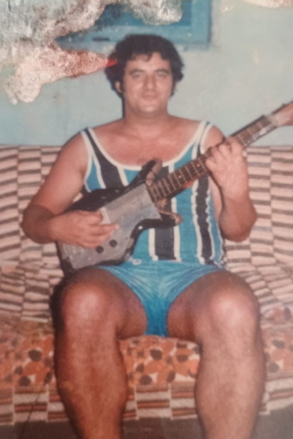 Fotografia antiga de um homem sentado tocando violão