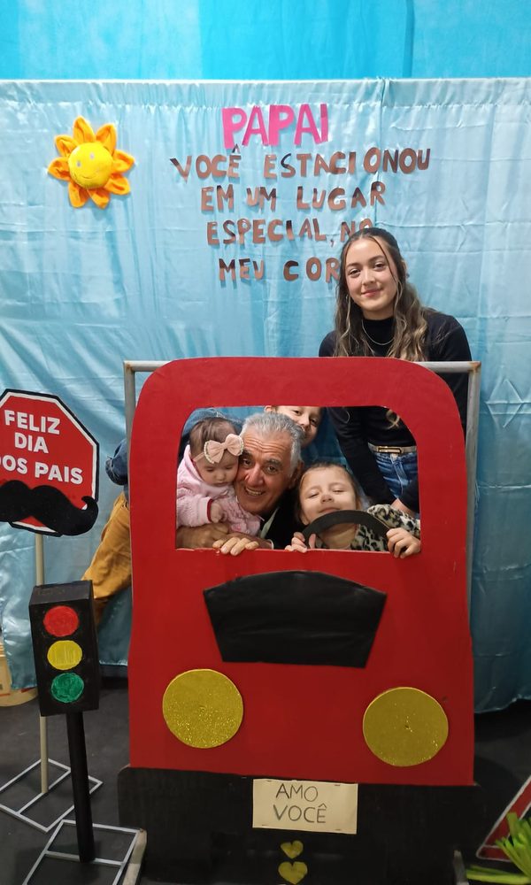 Sinval e os netos num painel de Dia dos Pais, dentro de um carro de papelão