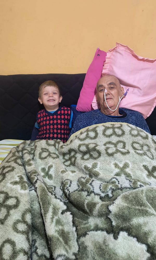 Sinval ao lado de um neto pequeno que sorri