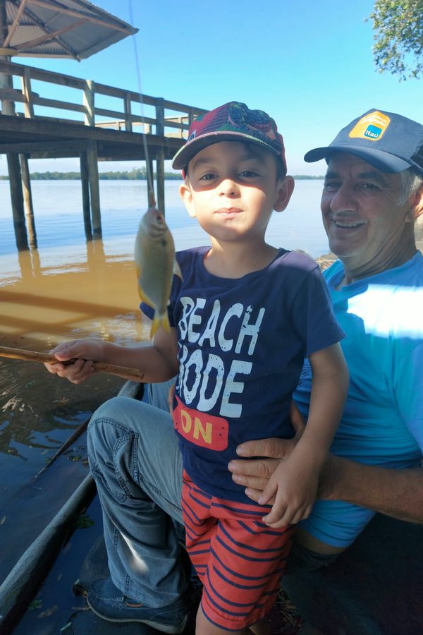Um senhor e um menino pescando num deque