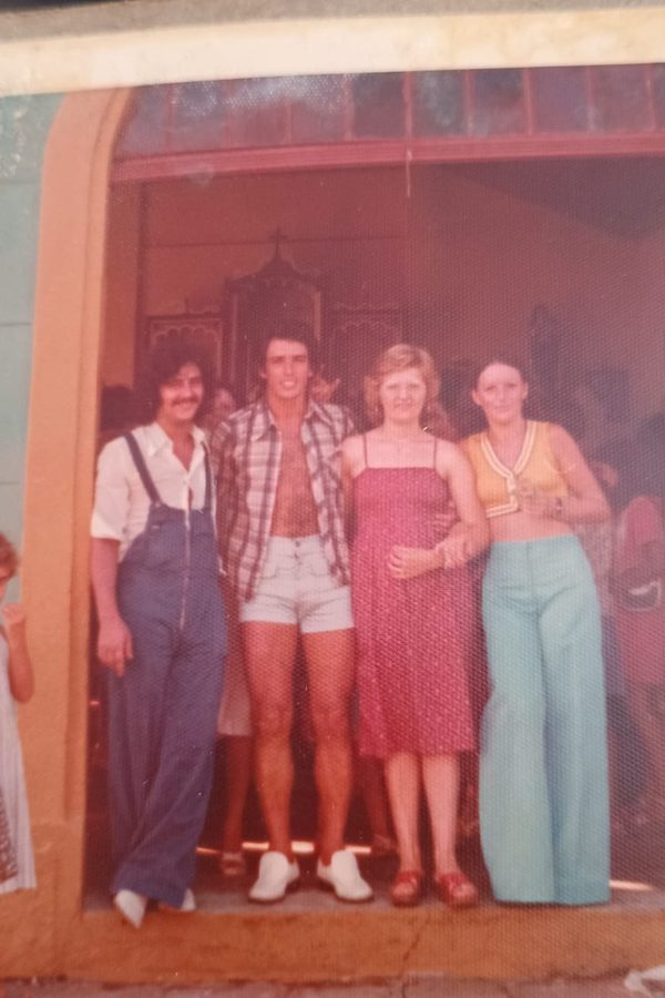 Fotografia antiga de um grupo de jovens diante de uma casa